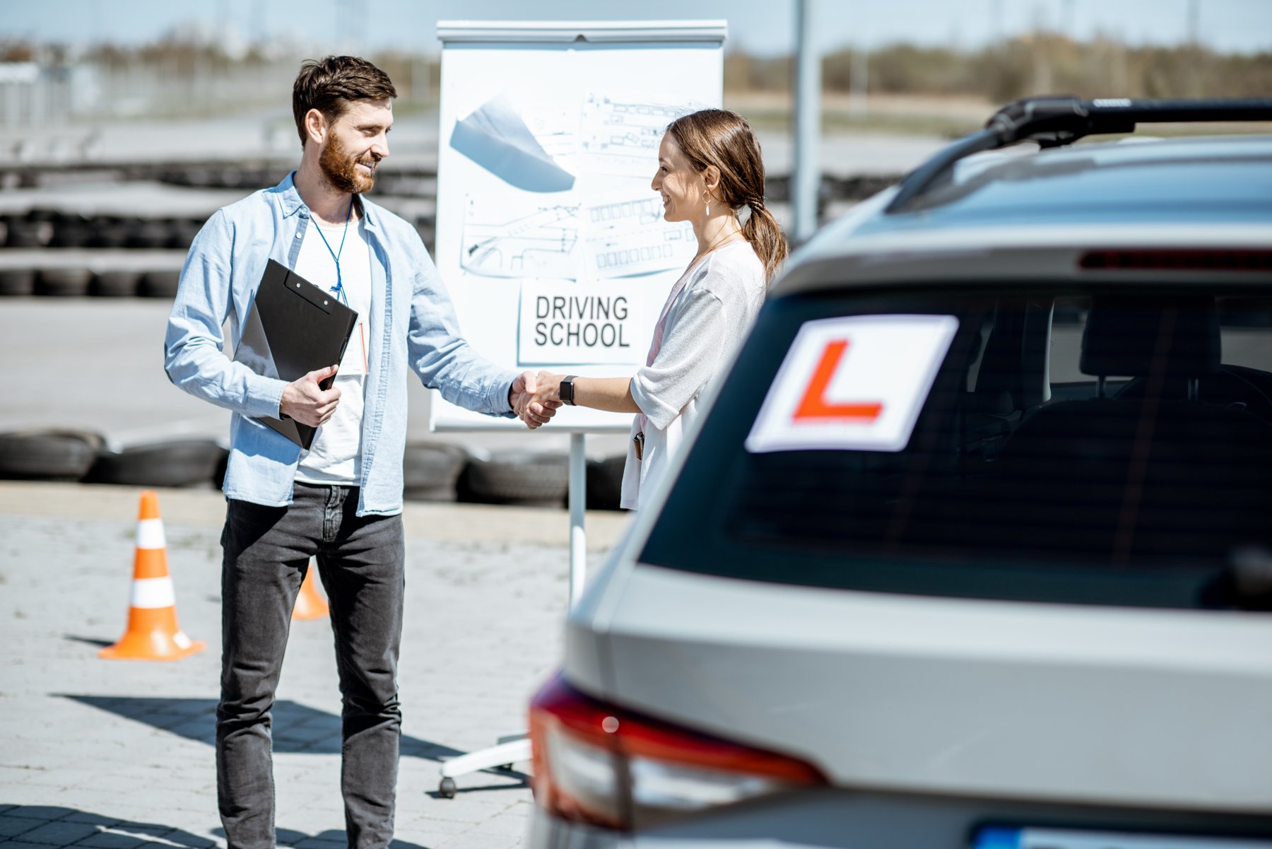 Fahrlehrer und Fahrschülerin bereiten eine Fahrstunde vor